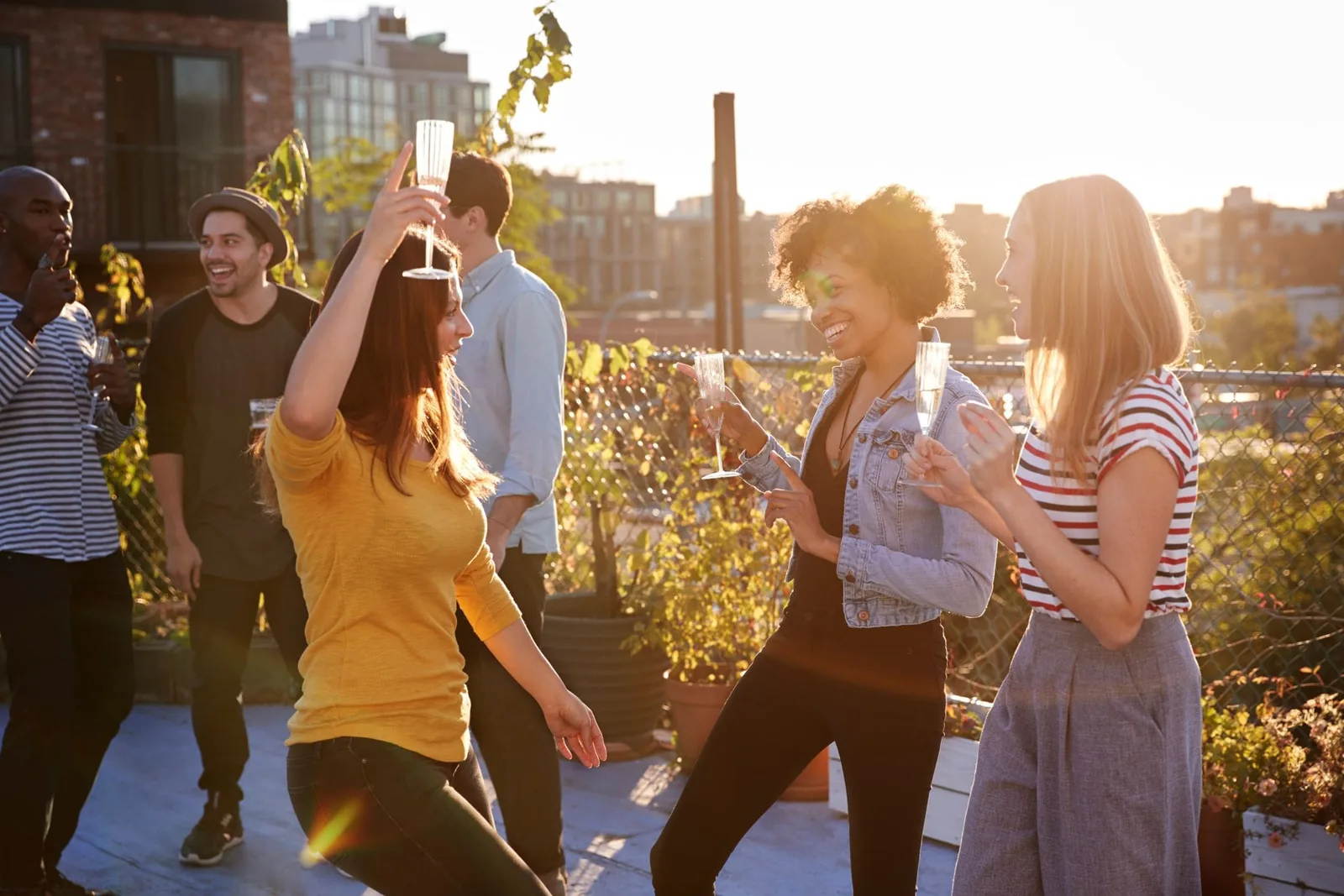 female-friends-dancing-and-drinking-at-a-rooftop