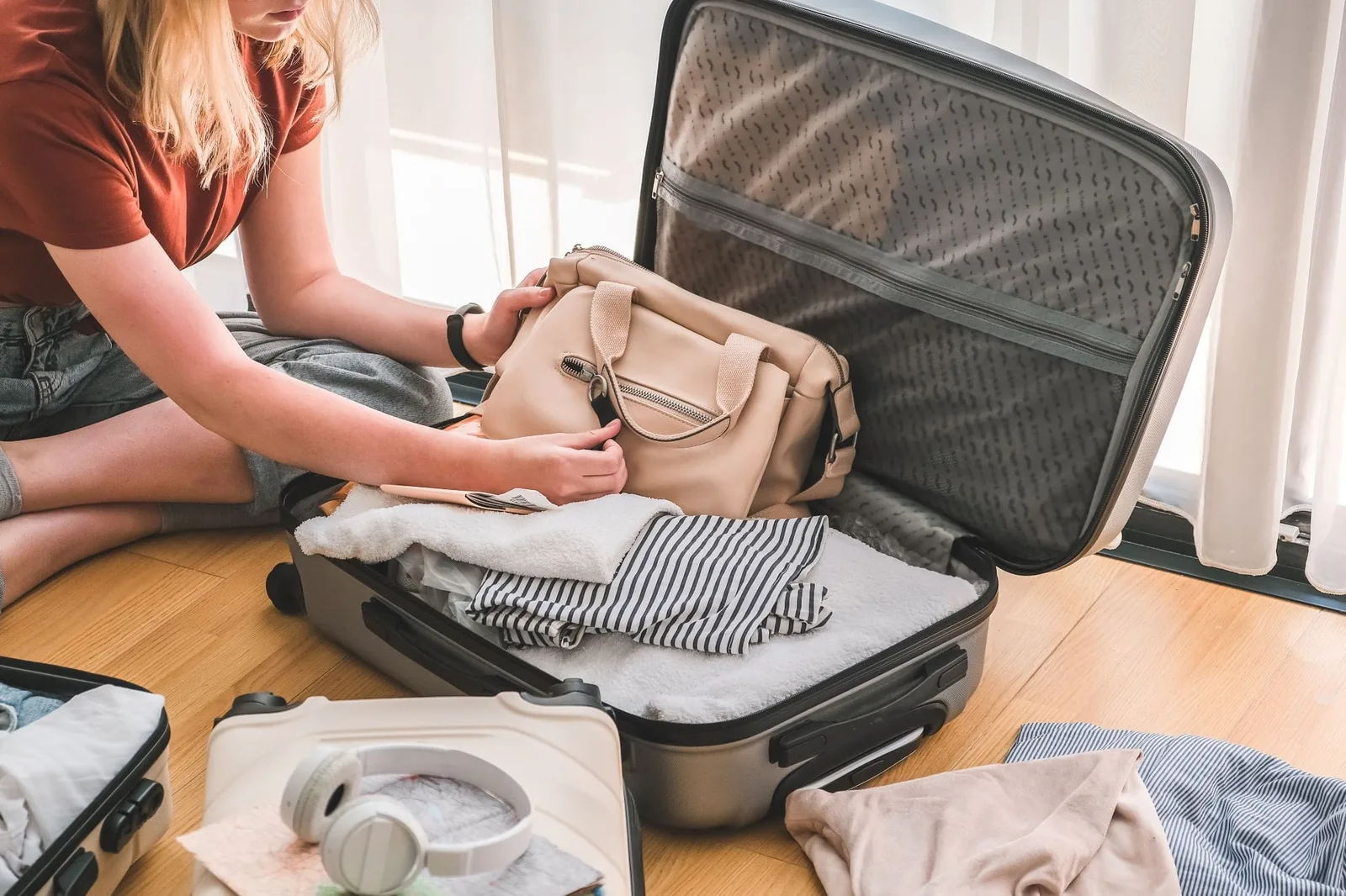 Girl packing luggage in suitcase and travel documents