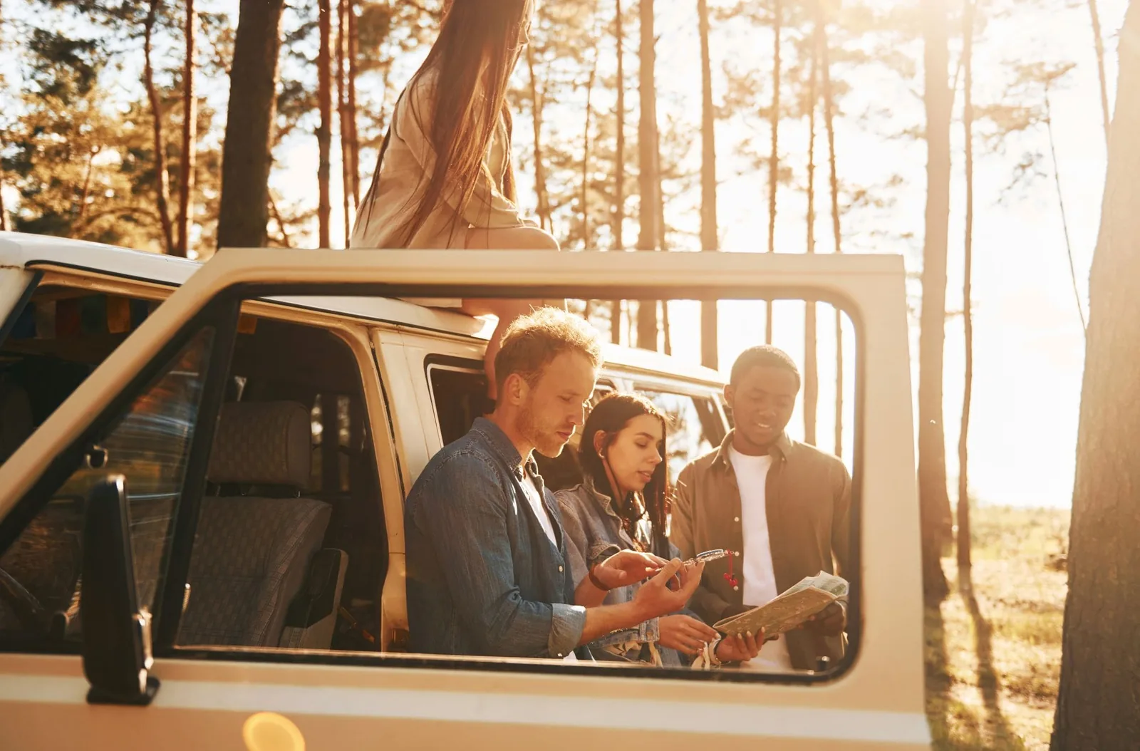 Group of young people is traveling together in the forest at daytime using map