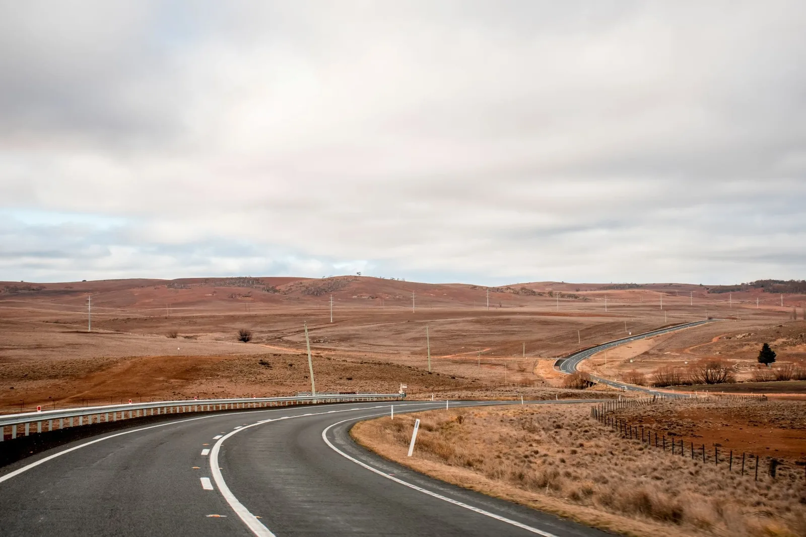 Open empty road surrounded by fields and farms in Outback Australia