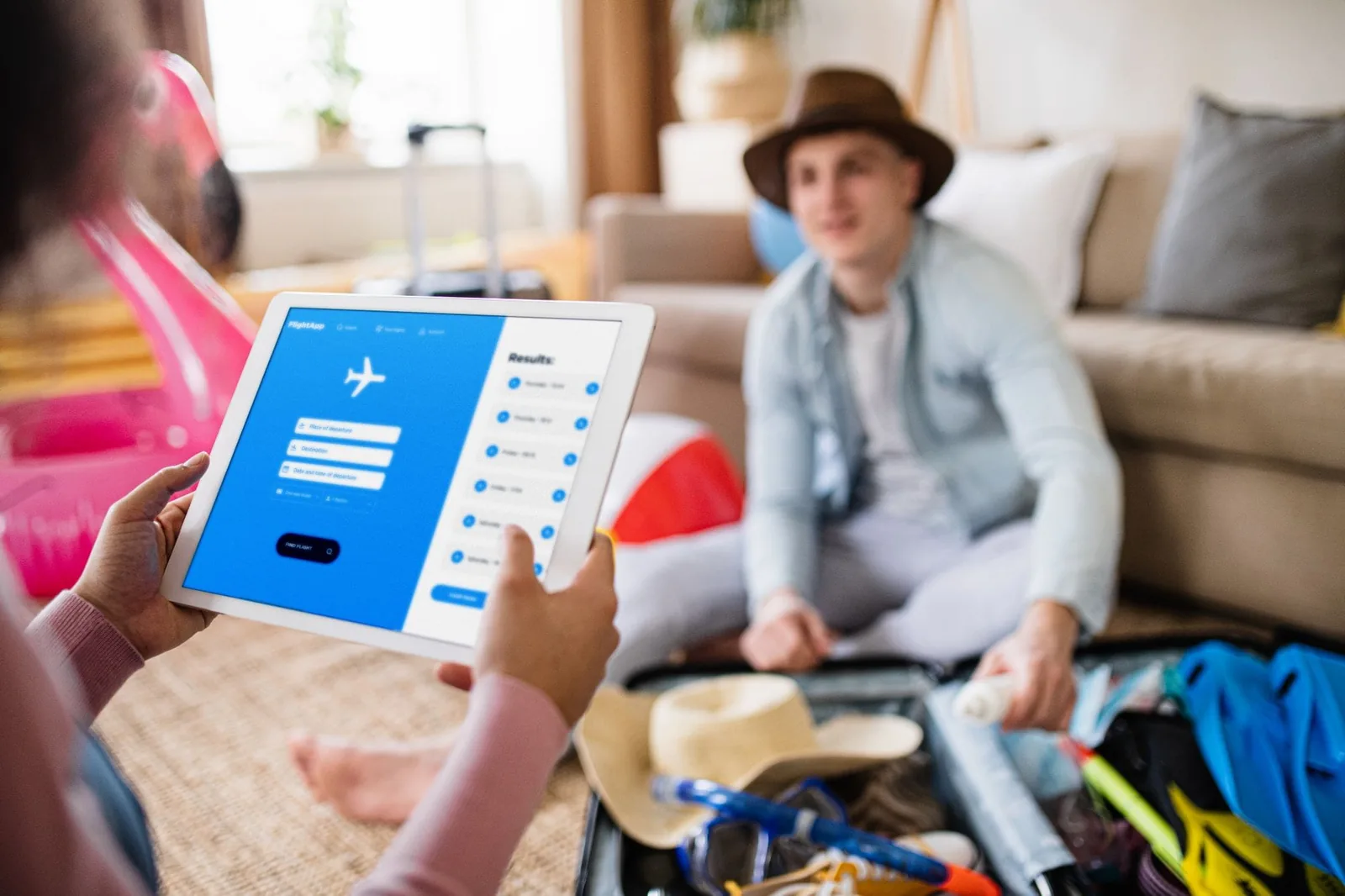 Unrecognizable couple with tablet planning holiday, booking flight